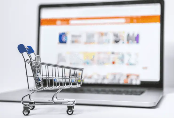 Shopping cart trolley in front of laptop for best shopify plugins