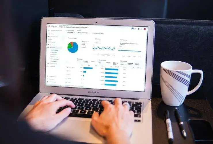 Woman working on a laptop with data analytics for digital marketing.