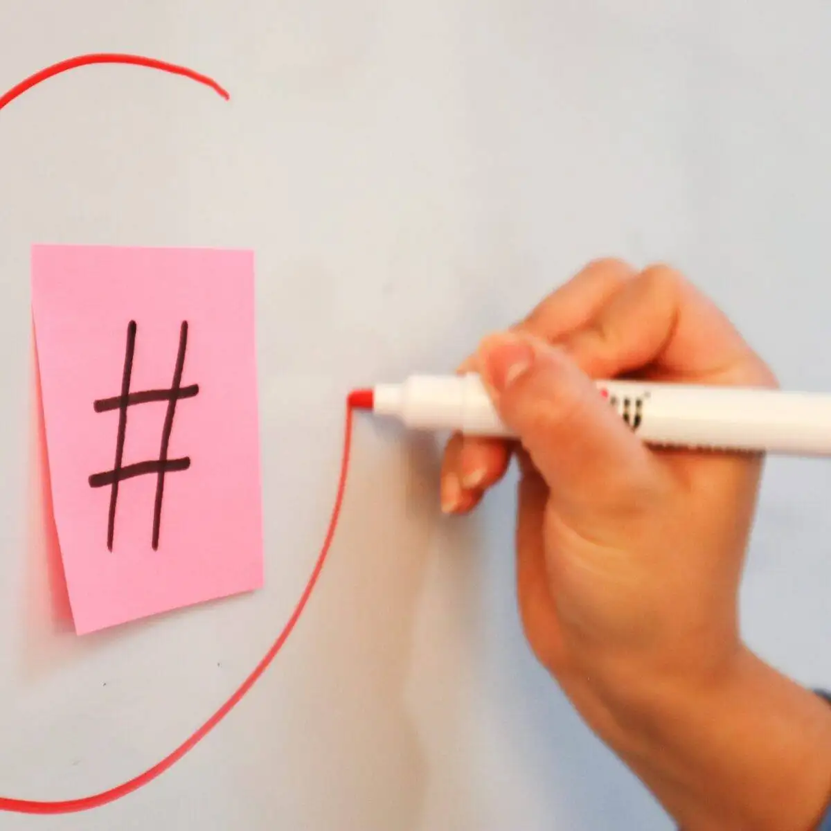 Do Hashtags Still Work? 2 Person circling the hashtag symbol on a piece of paper with a marker - Illustration for understanding hashtags