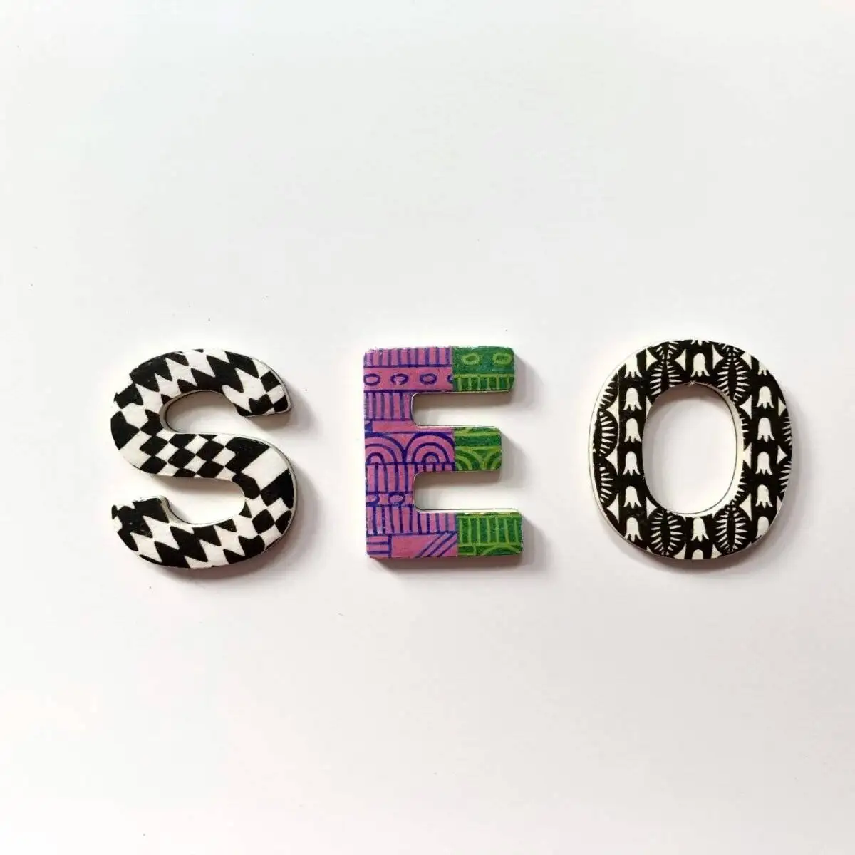 A Step-by-Step Guide on How to Write an SEO-Optimised Blog 2 Decorative letters with patterned designs spelling out SEO on a white background.