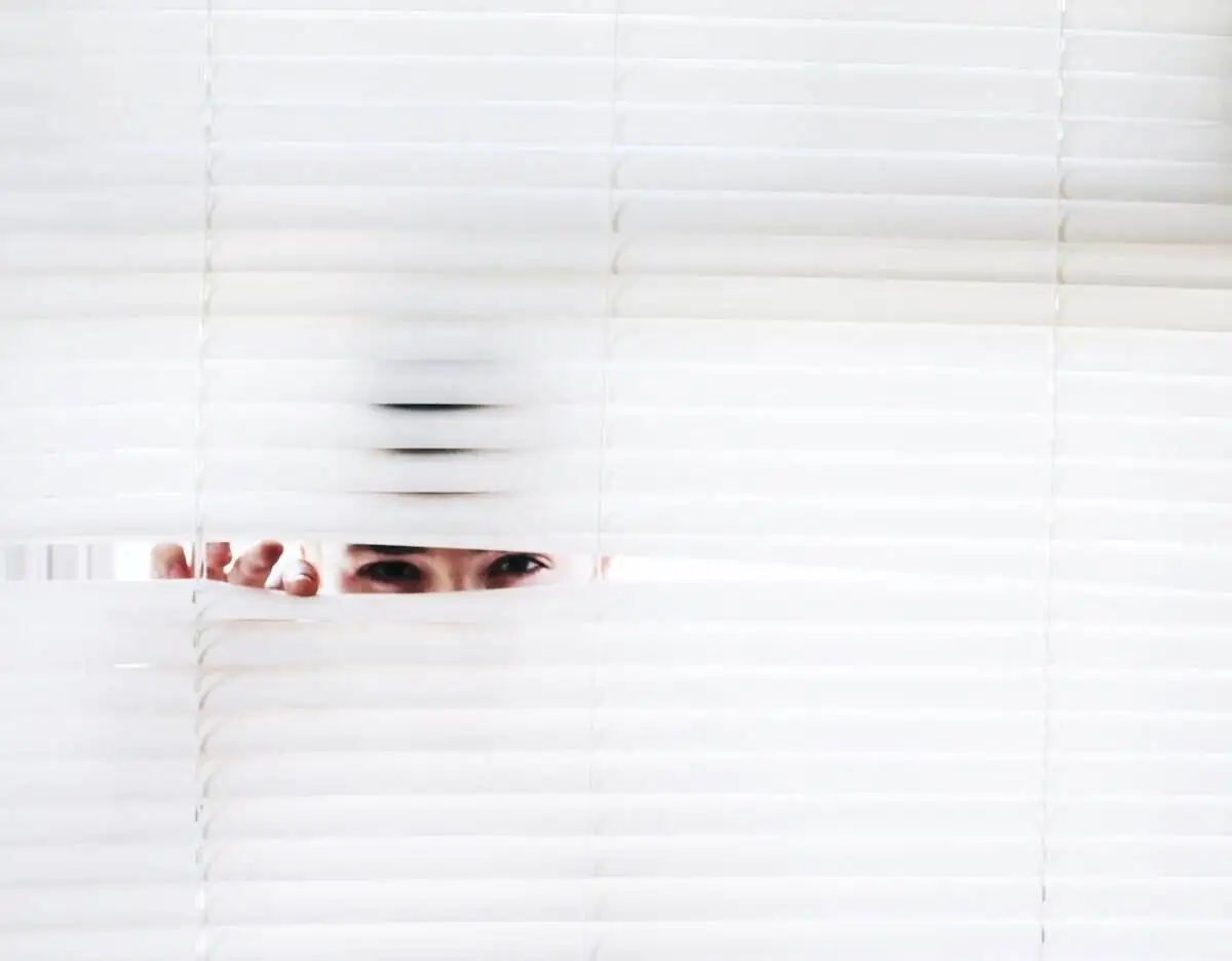 How To Spy On Your Competitor’s Google Ads 2 man spying through white blinds