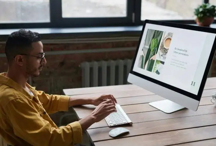 a man sitting at a desk using a computer looking up what an SEO company is