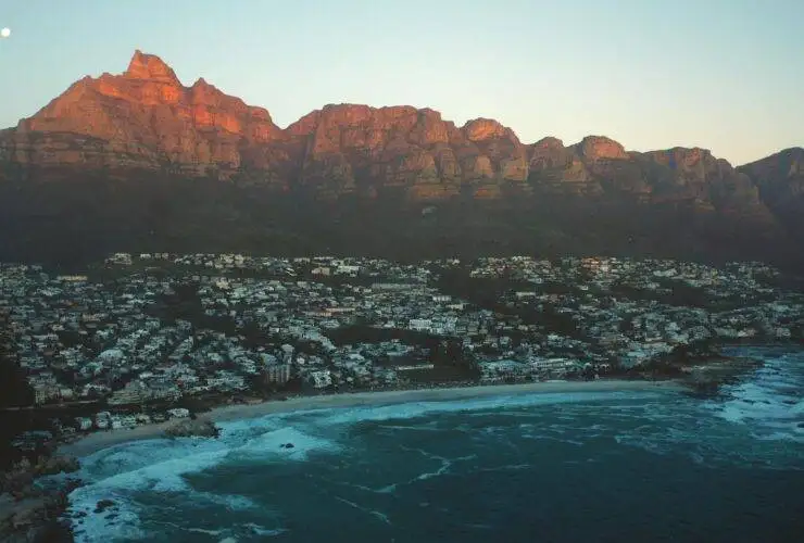 a city on a beach with mountains in the background in South Africa