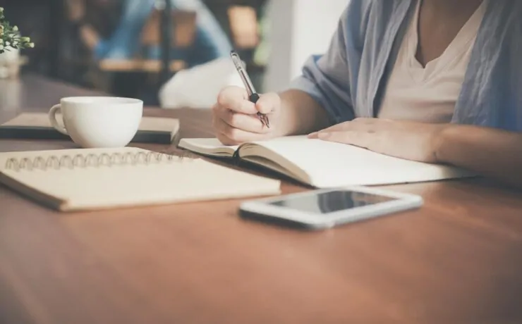 The Ultimate Guide to Choosing the Right SEO Optimization Company for Your Business 8 a person writing in a notebook about seo optimization companies