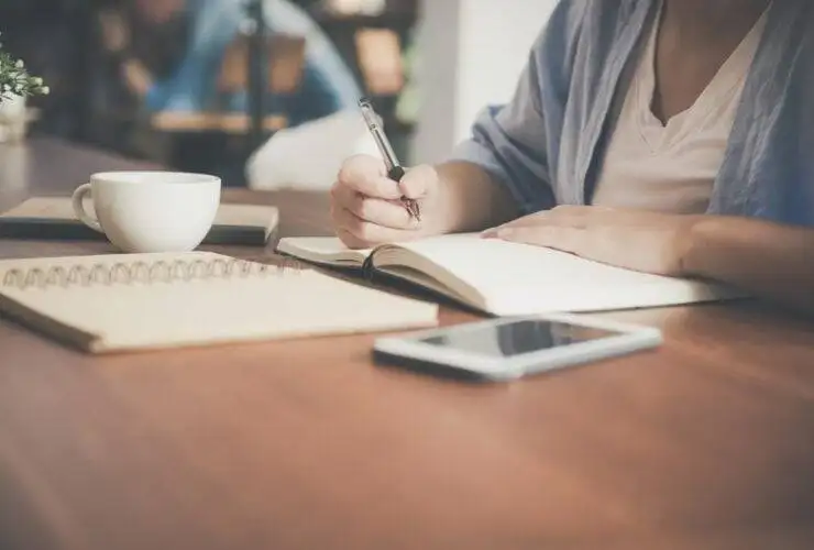 a person writing in a notebook about seo optimization companies