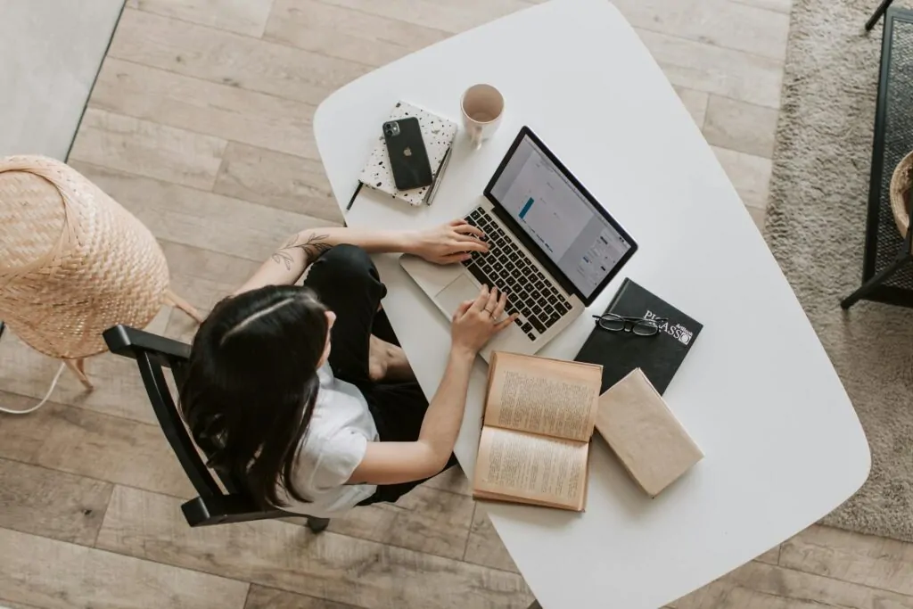 a woman sitting at a table using a laptop looking for SEO services near me 